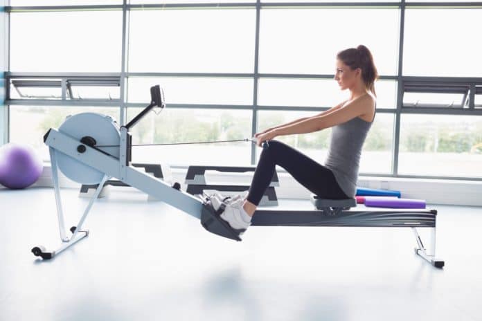 Woman working out on row machine in gym